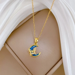 Macro shot of gold butterfly and blue moon pendant on soft white silk and beige velvet