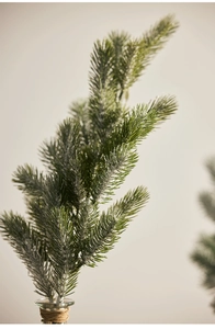 Close-up of frosted artificial pine branches for Christmas decor with realistic snow detail