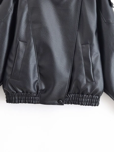 Détail de la veste en similicuir noir avec texture grainée et ourlet élastique