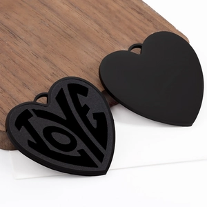 Detailed macro view of heart-shaped pendants with LOVE cutout and matte black finish