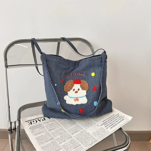 Detail view of cartoon puppy towel embroidery on blue striped canvas tote bag