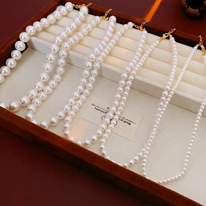 Colliers de perles élégants de tailles variées sur un plateau de bijoux en velours