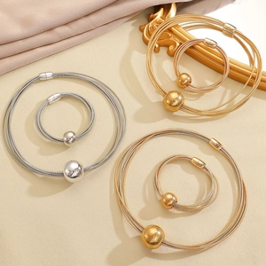 Dettaglio di girocolli e braccialetti in metallo a più fili nei colori oro e argento