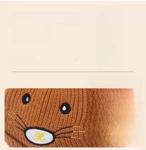 Détail du bonnet tricoté marron caramel pour bébé avec broderie d'animaux mignons