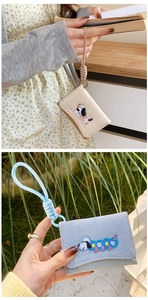 Detail of cute dachshund embroidery on beige and denim blue wristlet card holders