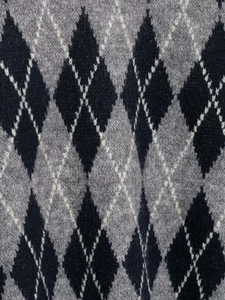 Macro view of argyle knit fabric detail in grey and black with soft wool texture