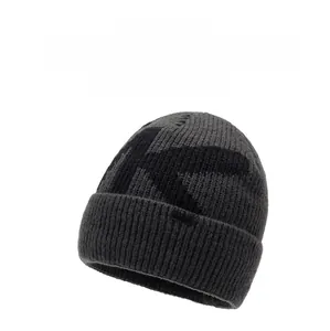 Close-up of thick dark grey knit beanie featuring black K jacquard and KNZKX logo label