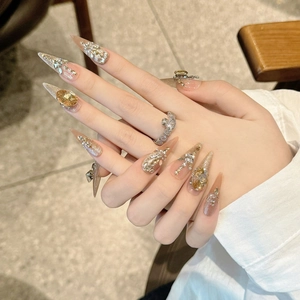Unghie finte di lusso color champagne glitter con strass e decorazioni in gemme preziose