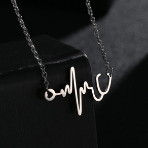 Collier stéthoscope et battement de cœur en acier inoxydable sur présentoir noir