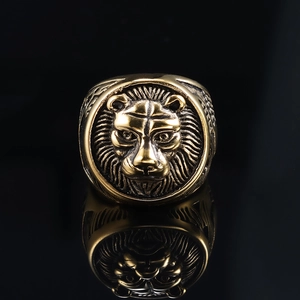 Macro shot of a vintage gold lion head ring with embossed details and a reflective finish