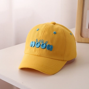 Close-up of MOON embroidery with bunny ears on yellow kids baseball cap fabric