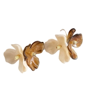 Bohemian acrylic flower tassel earrings with amber and cream resin petals on white background