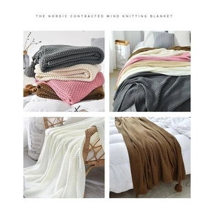 Detail view of waffle knit textures and elegant tassels on Nordic throw blankets