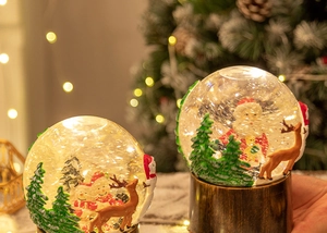 Gros plan de boules à neige de Noël lumineuses avec Père Noël, bonhomme de neige et LED