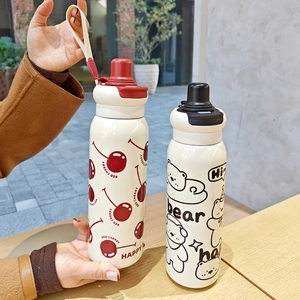 Detail of red cherry and black bear cartoon insulated bottles with portable fabric straps