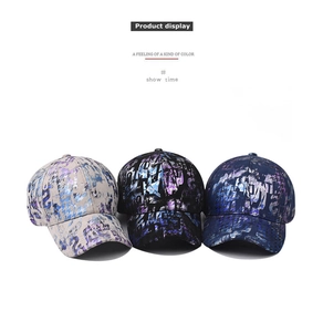 Detailed view of three tie-dye baseball caps with graffiti patterns in grey, black, and blue