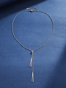 Detail of silver geometric Y-necklace with hollow triangle pendants on blue background