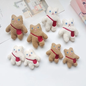 Detail of plush bear brooches in brown and white with red bag embroidery details