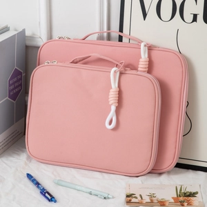 Pink laptop sleeve set with handle and woven zipper detail on canvas fabric