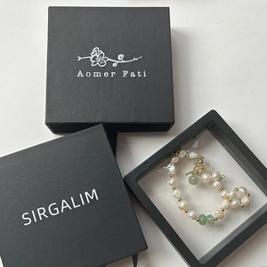 Detalle de pulsera de perlas con jade verde en elegante caja de exhibición negra PE