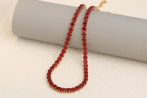 Detail of 18K gold plated tennis necklace with vibrant red round-cut gemstones