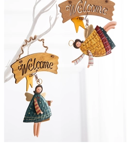 Dettaglio di angeli decorativi con targa Welcome in legno e statuine in metallo dipinte