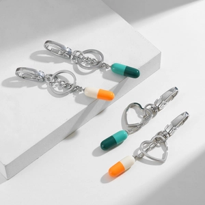Detailed view of color-block capsule pendants with heart and round metal keyrings