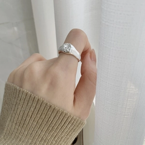 Detailed view of an irregular textured silver ring worn on the index finger