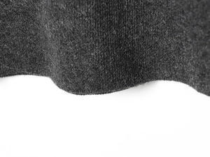 Vue détaillée de la texture du tissu en maille gris foncé avec fibres de laine douces
