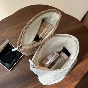 Detailed macro view of woven cotton cosmetic bags on a dark wood table with skincare items