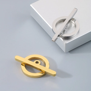 Macro view showing gold and silver toggle clasps on a modern geometric display