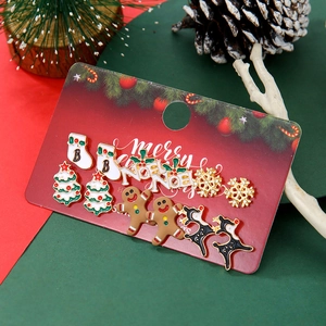 Close-up of Christmas stud earrings set featuring snowflake and reindeer on festive card