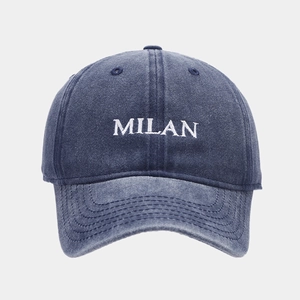 Detailed view of white MILAN embroidery on washed navy blue denim vintage baseball cap