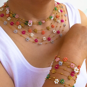 Detail of colorful beaded flower necklace and bracelet set worn by a model