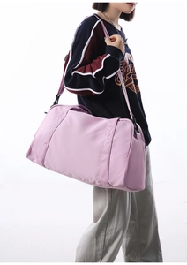 Model showing large pink gym bag with shoulder strap for travel and sports
