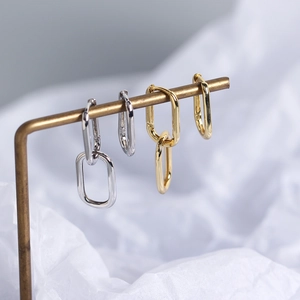 Close-up of geometric S925 sterling silver chain link earrings in gold and silver
