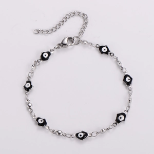 Silver stainless steel chain bracelet with black and white evil eye charms on white background