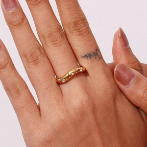 Close-up of 18K gold plated wavy ring with micro-pave crystals on model finger