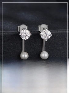 Macro shot of S925 sterling silver ear studs featuring moissanite and white pearls