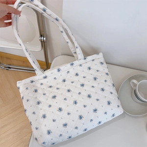 Gros plan détaillé du sac cabas matelassé en coton avec motif floral bleu et surpiqûres