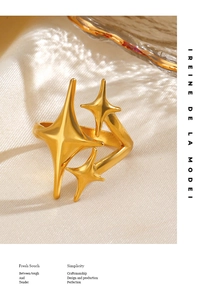 Detailed view of polished gold star open ring on minimalist white fabric background