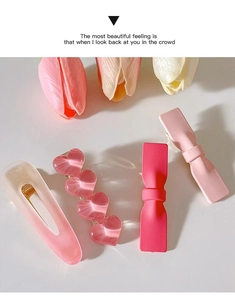 Detailed view of four pink Y2K style hair clips featuring hearts and bows on white surface