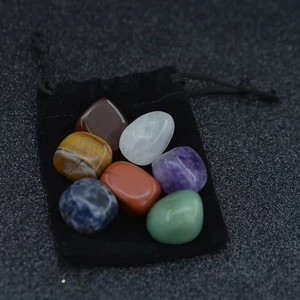 Detailed view of 7 natural polished chakra stones set with a black velvet storage pouch