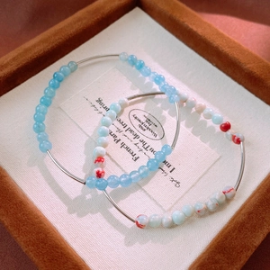 Close-up of blue aquamarine and marble pattern beaded bracelets on a jewelry display box