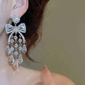 Sparkling silver bow tassel earrings with geometric crystals for a luxury women's look