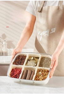 Detail of a 6-compartment transparent spice organizer box with various seasonings