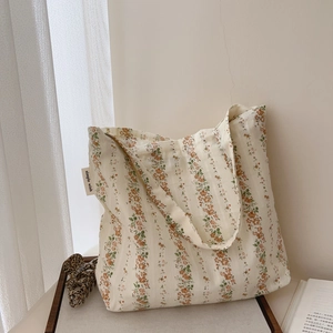 Detail of floral cotton tote bag with side label simple wish in soft natural lighting