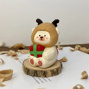 Detail of hand-carved wooden bear figurine in reindeer hat holding a red gift box