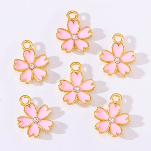 Detail of pink cherry blossom alloy charms with gold plating and clear rhinestone center