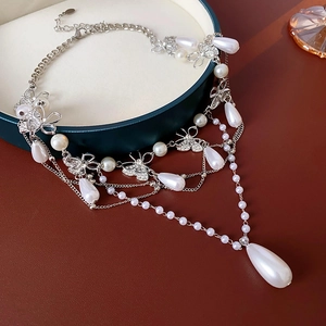 Detail of silver butterfly necklace with multi-layer pearls and sparkling crystals